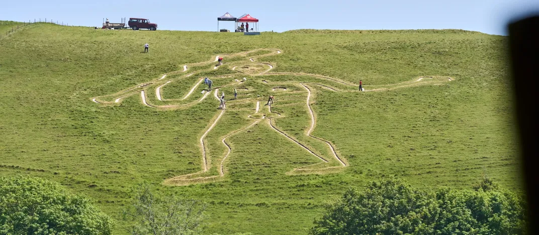 A Cerne Abbas Giant újrakrétázása a domboldalon, a helyreállító csapattal a domb tetején
